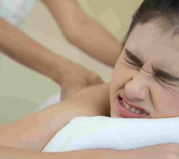 Wanita meringis saat menjalani body massage untuk membantu meredakan otot tegang.