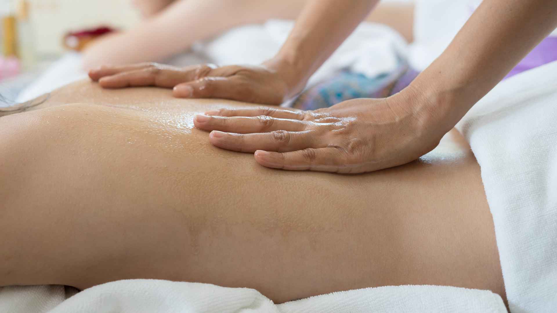 Tangan terapis memijat punggung saat treatment body massage 60 atau 90 menit di MurniCare Wellness 